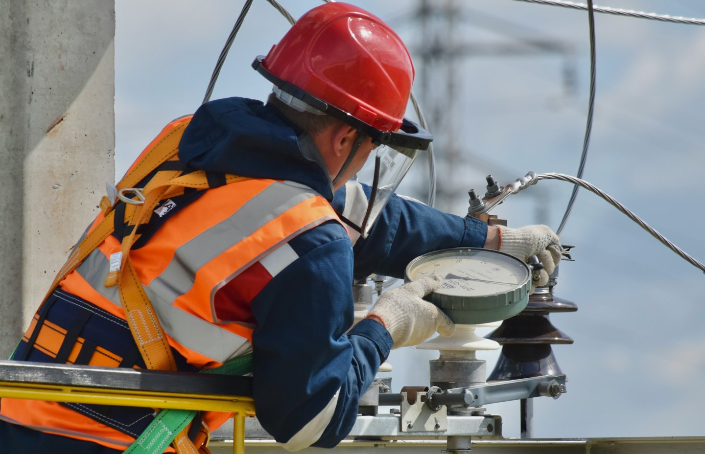 Techniker in Warnweste stellt elektrische Geräte im Freien ein.